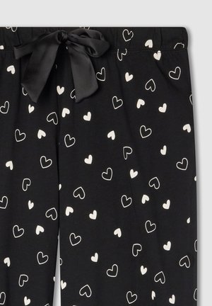 Pantaloni a pigiama neri con vita regolabile. Motivo a cuori bianche sparsi su tutta la stoffa. Realizzati in materiale morbido con una finitura opaca.