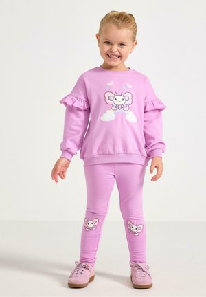 Vaaleanpunainen huppari, jossa on röyhelöhihoja ja perhosgrafiikka; vastaavat vaaleanpunaiset legginsit, joissa on samanlaisia perhoskoristeita.