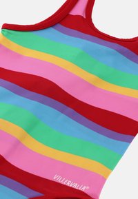 Yhden palan uimapuku, jossa on rohkeita, aaltoilevia raitoja punaisessa, vaaleanpunaisessa, vihreässä, sinisessä, keltaisessa ja violetissa, punaisella reunuksella ja "VILLERVALLA"-logolla.