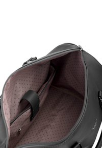 Black leather bag with smooth texture, featuring a zippered closure. Interior has a pink polka dot pattern and a zippered pocket for organization.