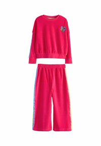 Světlý růžový bavlněný loungewear set, který obsahuje dlouhý rukáv s nášivkou srdce a odpovídající šortky s vícebarevnými postranními proužky.