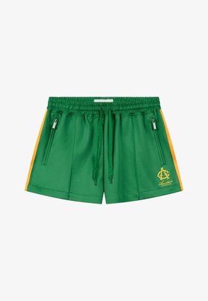 Grüne Sportshorts mit gelben Streifen an den Seiten, elastischem Bund mit Kordelzug, Reißverschlusstaschen und einem gelben Logo am linken Bein.