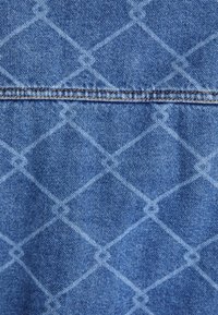 Denim tkanina z modro-belimi rombi. Površina je gladka, z kontrastnim šivom ob šivih.