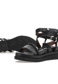 Černé kožené platformové sandály s náramky na kotníky, stříbrnou sponou a patentním knoflíkem, zobrazené na bílém pozadí.