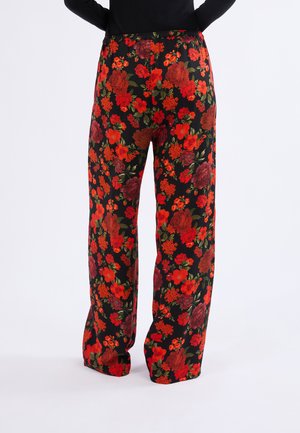Pantalones de estampado floral con un fondo negro adornado con flores rojas y verdes. Elaborados en una tela ligera con un ajuste relajado y cinturilla elástica.
