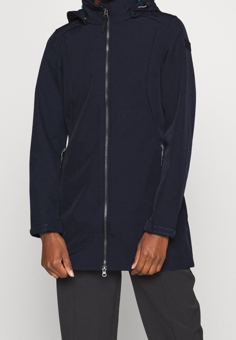 Giacca softshell blu navy con zip frontale, cappuccio regolabile e tasche laterali. Presenta un design elegante, polsini testurizzati e accessori minimali.