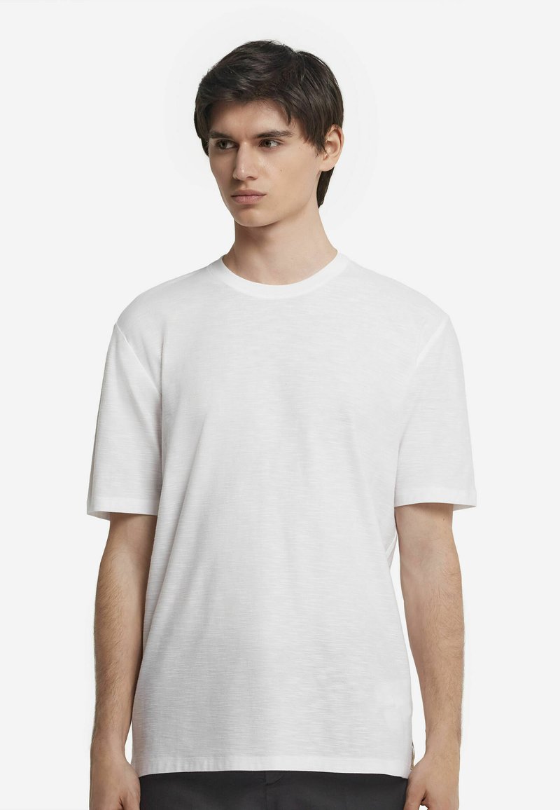 Hvid crew neck t-shirt med korte ærmer, lavet af et letvægtsstof, med et subtilt struktureret mønster og en afslappet pasform.