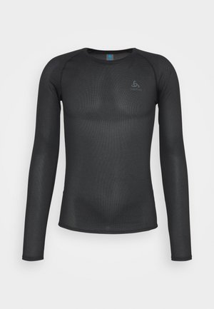 T-shirt de compression à manches longues noir en tissu respirant et texturé. Doté d'un col rond et d'un logo sur la poitrine. Surface lisse.
