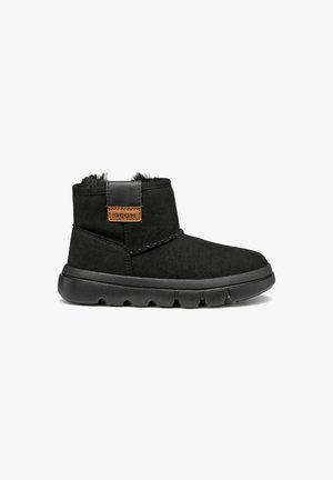 Botas de tobillo negras hechas de suave ante, con un cuello de piel sintética, acento de cuero y una suela de goma texturizada con un dibujo pronunciado.
