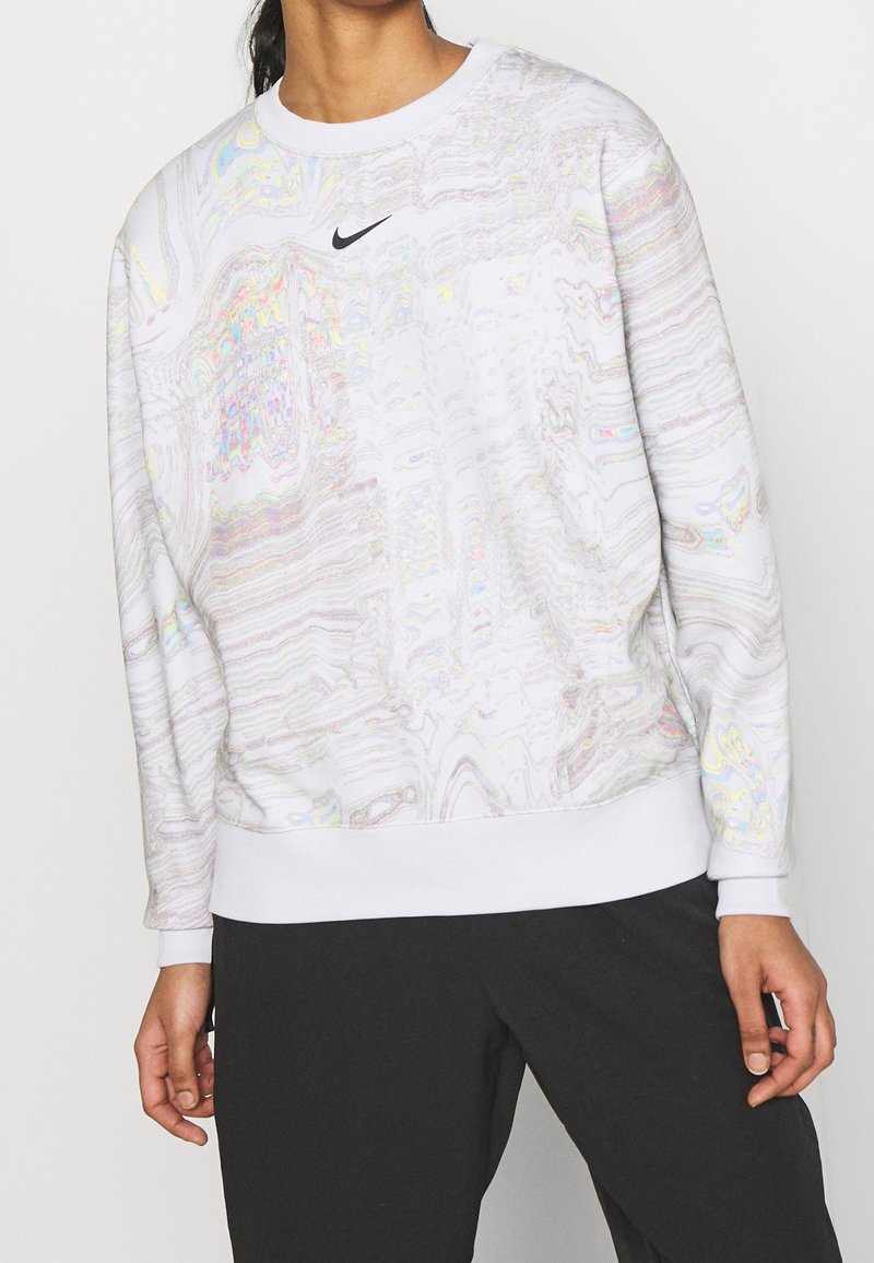 Sweat-shirt blanc avec un motif fluide et irisé, des poignets et un ourlet côtelés, et un petit logo Nike noir sur la poitrine.