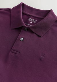 Tricou polo violet din țesătură texturată, cu un guler cu trei nasturi, logo cusut pe piept și croială regular fit.