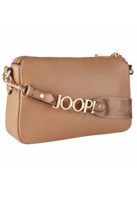 Borsa a tracolla in pelle marrone chiaro con finitura testurizzata, chiusura con zip e dettaglio in logo "JOOP!" in tonalità oro sulla tracolla in tessuto. Forma compatta rettangolare.