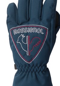 Rukavice z tmavě modrého nylonu se staženým zápěstím. Na oblasti dlaně se nachází velké logo Rossignol s vyšíváním v červené a bílé barvě.