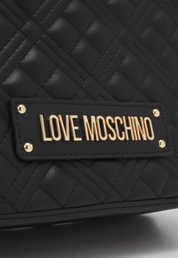 Svart vadderad handväska med en texturerad yta, med en guldfärgad "LOVE MOSCHINO"-plakett och metallackcenter.