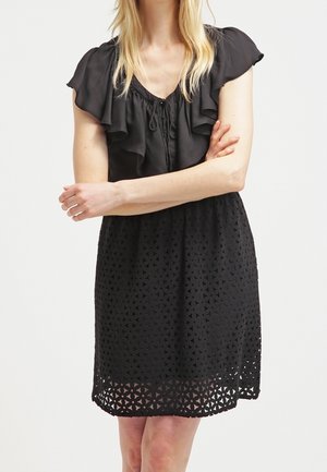 Zwarte jurk met geplooide korte mouwen, een ingesnoerde taille en een gestructureerd uitgesneden patroon in de rok. Lichtgewicht materiaal, lengte boven de knieën.