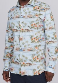 Jasnoniebieska koszula z długim rękawem, zapinana na guziki, w tropikalny wzór z palmami, kwiatami, zabytkowymi samochodami i plażowymi scenami. Miękka tkanina.