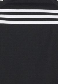 Schwarzes Stoffkleidungsstück mit strukturierter Oberfläche, versehen mit drei horizontalen weißen Streifen im oberen Bereich. Einfaches Design, keine weiteren Details.