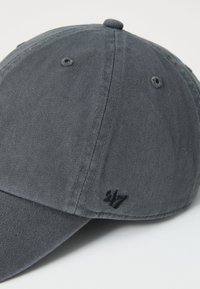 Gray corduroy cap with a curved brim, featuring subtle texture and a small embroidered logo on the side.