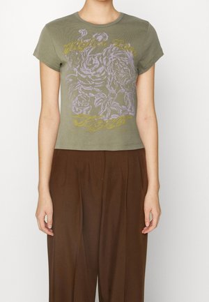 Oliwkowa krótka koszulka z miękkiej bawełny, z grafiką lawendowej i żółtej róży oraz napisem "Wyższa Miłość" w kursywie.