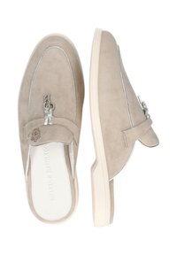 Zapatos beige de ante sin cordones con suela blanca. Presentan herrajes en tono plata y detalles cosidos a lo largo del borde superior.