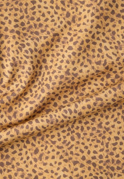 Ύφασμα με λεοπάρ μοτίβο, χρυσό κίτρινο φόντο με καφέ κηλίδες, με υφή και ραβδωτή επιφάνεια. Διακριτές ρυτίδες για μεγαλύτερο βάθος.