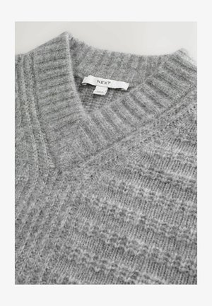 Gray knitted sweater with a V-neck, featuring ribbed and textured patterns. Label reads "NEXT." Soft, fuzzy material.