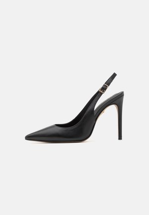 Czarne skórzane buty na wysokim obcasie, typu slingback, z czubkiem w szpic, wyposażone w cienki obcas i regulowany pasek na kostkę z zapięciem w kolorze złota.