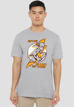 Young man wearing gray T-shirt featuring The Flash character in running pose with text "Can't Stop The Flash."