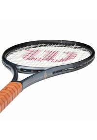 Tennissla met een zwart frame, witte snaren, een rood logo en een beige grip, schuin geplaatst op een witte achtergrond.