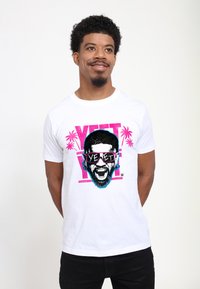 Bílé bavlněné tričko s barevným motivem tváře s brýlemi, obklopené růžovými palmami a s nápisem "YEET" tučnými písmeny.