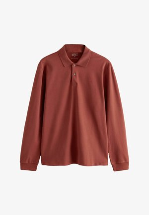 Polo à manches longues de couleur rouille, fabriqué en coton avec un col côtelé. Il possède deux boutons et un petit logo brodé sur la poitrine.