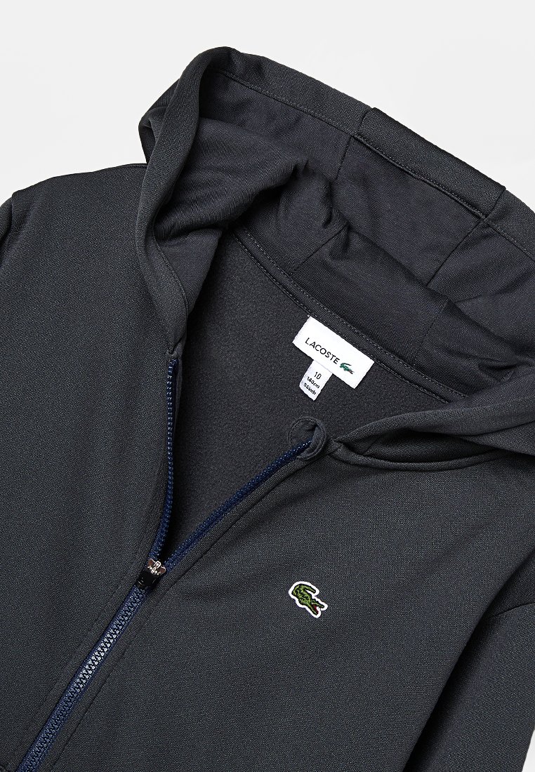 Czarna bluza z kapturem na zamek, wykonana z gładkiego materiału, z wyściełanym kapturem i małym haftowanym zielonym logo krokodyla z przodu.