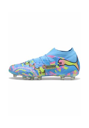 Chaussure de football bleue avec col haut, motifs pixellisés multicolores, logo Puma jaune et rose, et crampons transparents sur la semelle.