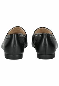 Schwarze Lederloafers mit glatter Oberfläche, niedrigem Absatz und dekorativer Naht an der Rückseite. Innenfutter aus hellfarbigem Material.