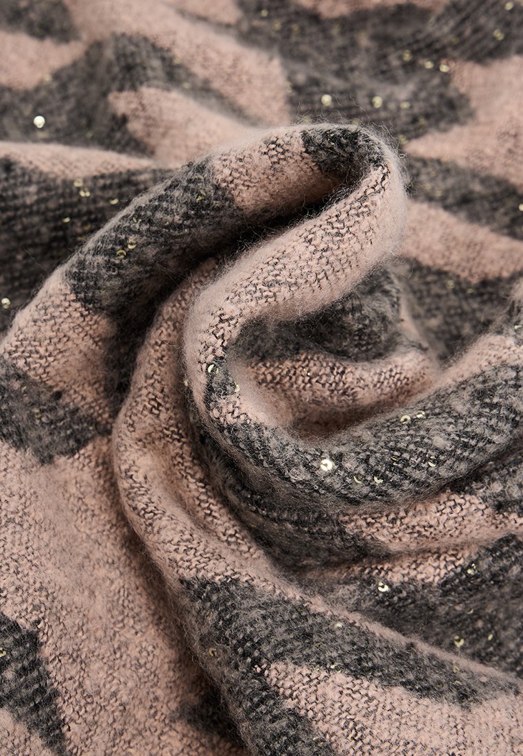 Tejido de punto suave con patrones geométricos en marrón y negro, salpicado de pequeños brillantes dorados, doblado en suaves ondas.