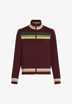 Burgundy-värinen vetoketjullinen takki, jossa on korkea kaulus, vihreät, keltaiset ja punaiset raidat rinnassa sekä ribbaus hihansuissa ja helmassa.
