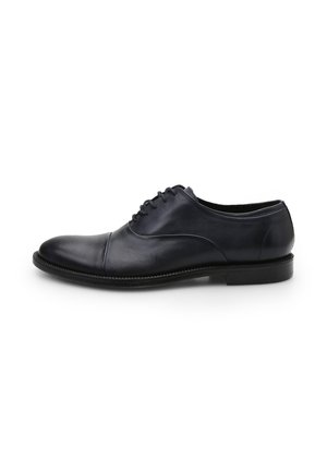 Chaussure habillée en cuir noir avec un bout arrondi, une couture subtile sur le bout, un design à laçage et un petit talon empilé. Texture lisse et silhouette élégante.