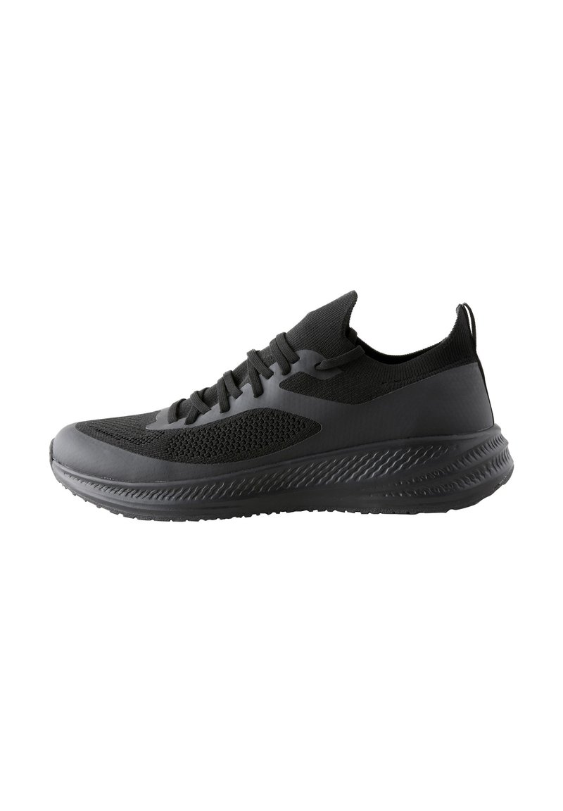 Black athletic shoe with a mesh upper, cushioned sole, and textured accents. Features slim lacing and a pull tab at the heel.