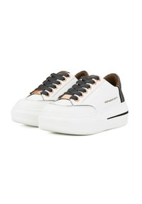 Sneakers bianchi in pelle con lacci neri, caratterizzati da dettagli in oro rosa e una suola spessa bianca con una striscia orizzontale nera.