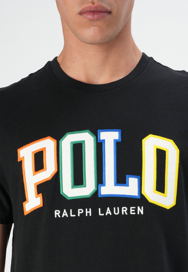 Czarna bawełniana koszulka z dużą, kolorową grafiką "POLO" w kolorach pomarańczowym, zielonym, niebieskim i żółtym, z napisem "RALPH LAUREN" poniżej w białym kolorze.