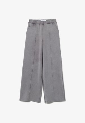 Pantalones de pierna ancha grises, confeccionados en una tela suave, con una cinturilla elástica, dos bolsillos laterales y detalles de costura sutiles.