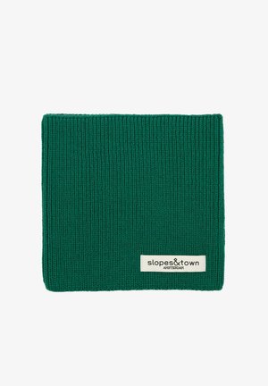 Berretto verde a maglia con texture a coste. Presenta un'etichetta crema con la scritta "slopes&town AMSTERDAM" in carattere nero.