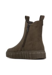 Botas de tobillo verde oliva con cremallera lateral, material de ante texturizado y suela de goma gruesa y estriada. Dos tiradores en el cuello.