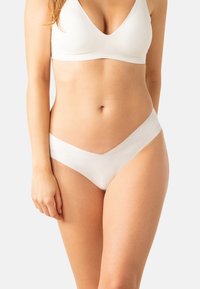 Ensemble de bralette et bikini blanc à côtes ; présente un design en V, une texture douce et des bords sans couture pour le confort.