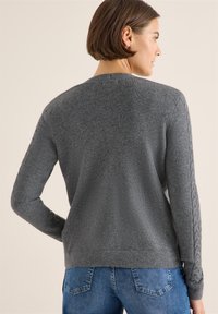 Maglione grigio a maglia rasata con scollo rotondo, caratterizzato da dettagli a treccia testurizzati sulle maniche e orlo a costine. Vestibilità casual, materiale morbido.