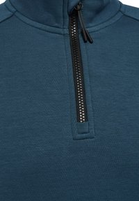 Close-up van blauwe pulloverstof met zwarte kwart-rits en trekkoorden bij de kraag.