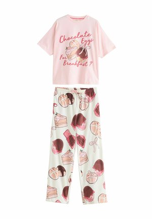 Pink cotton pajama set featuring a short-sleeve top with a dessert graphic and cream pants adorned with colorful dessert patterns.