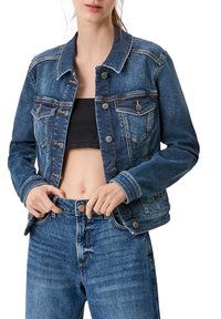 Blå denimjacka med klassisk skärning, framknappar och bröstfickor. Har en blekt textur och kontrasterande sömmar.