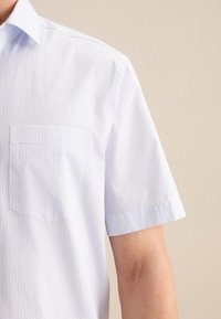 Camicia a maniche corte di colore blu chiaro con un motivo circolare sottile, dotata di tasca sul lato sinistro del petto e colletto standard.