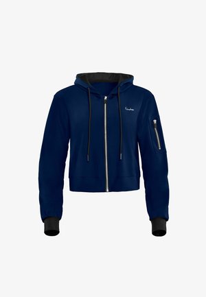 Marineblå cropped hoodie med sort foring, lynlåsåbning foran, hætte med snor og en lomme på venstre ærme. Har ribbede manchetter.